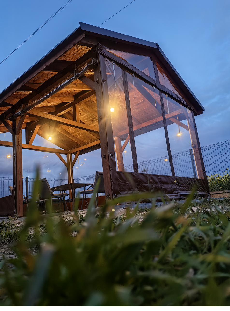 Altana ogrodowa z plandeką przeźroczystą – oświetlona nocna realizacja